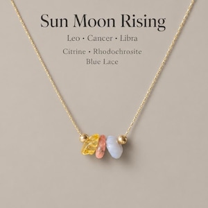 May include: A gold-coloured necklace with three gemstones: yellow citrine, pink rhodochrosite, and blue lace. The necklace has small gold beads and the text "Sun Moon Rising".