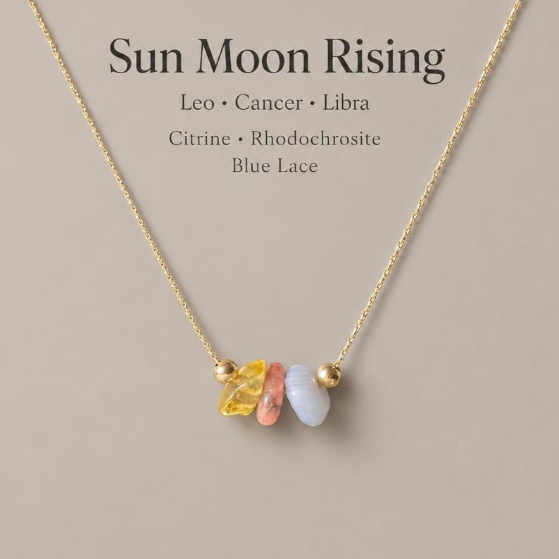 May include: A gold-coloured necklace with three gemstones: yellow citrine, pink rhodochrosite, and blue lace. The necklace has small gold beads and the text "Sun Moon Rising".
