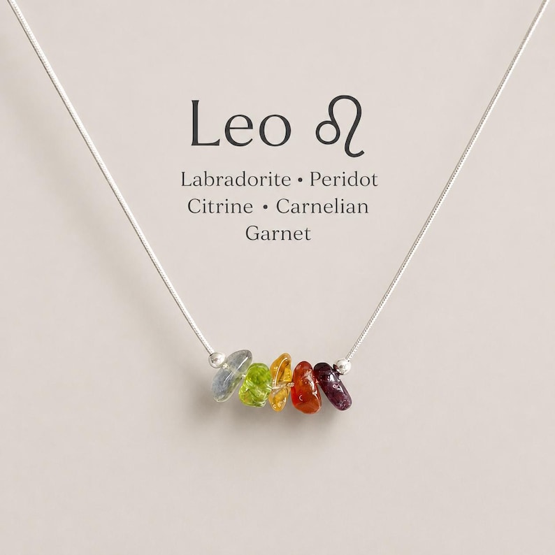 Pu&ograve; includere: Una collana a catena argentata con cinque piccole pietre preziose levigate e irregolari nei toni del blu, verde, giallo, arancione e rosso scuro. Il testo sopra riporta Leo, il simbolo zodiacale del Leone e i nomi Labradorite, Peridot, Citrine, Carnelian, Garnet.
