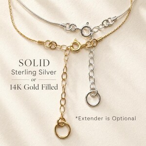 May include: Close-up of two necklaces, one silver and one gold. The gold necklace is 14K gold filled, and the silver necklace is solid sterling silver. The text on the image reads "SOLID Sterling Silver or 14K Gold Filled". An extender is optional.