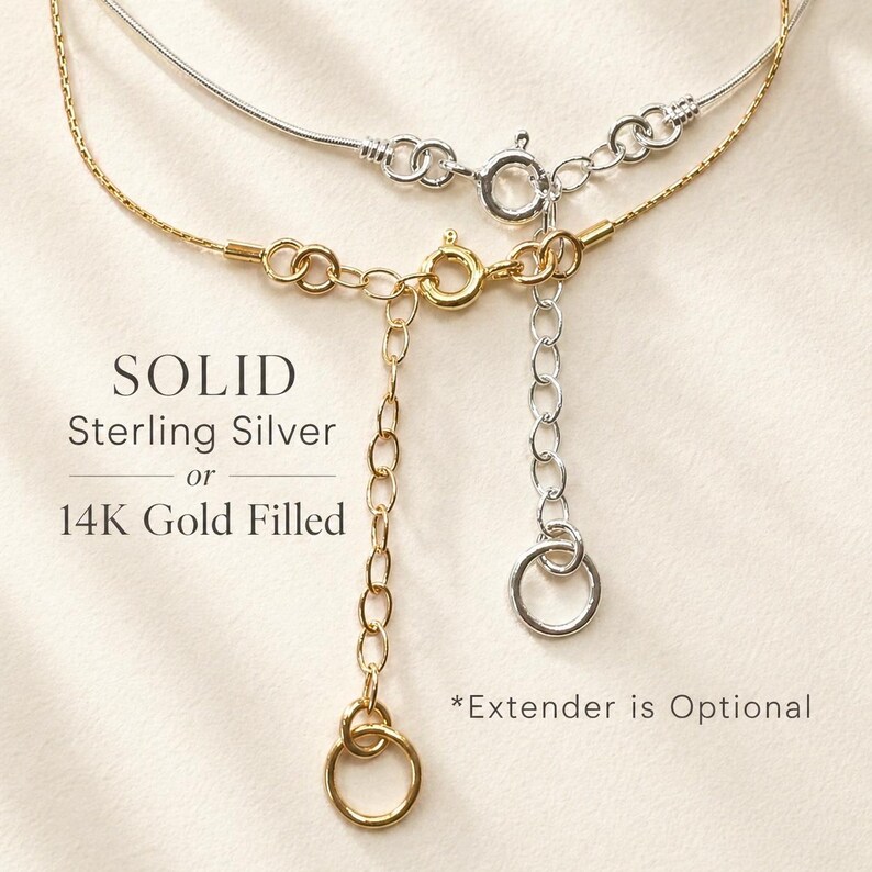 May include: Close-up of two necklaces, one silver and one gold. The gold necklace is 14K gold filled, and the silver necklace is solid sterling silver. The text on the image reads "SOLID Sterling Silver or 14K Gold Filled". An extender is optional.