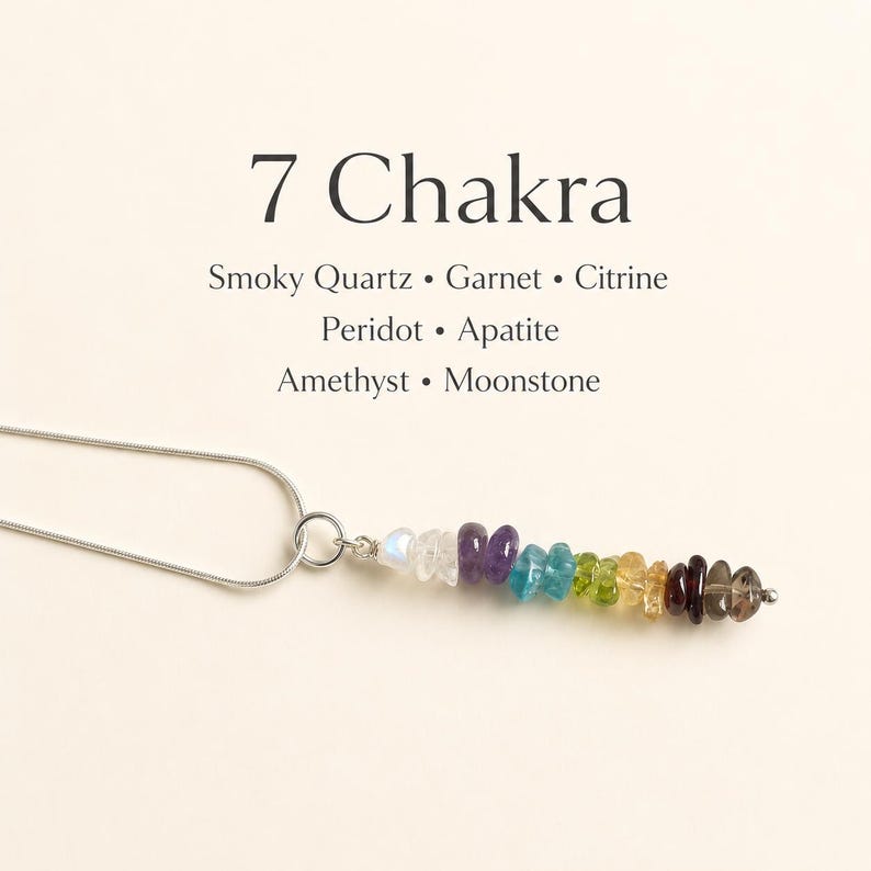 Pu&ograve; includere: Una collana con catena d'argento con un ciondolo con sette pietre preziose colorate. Le pietre sono disposte in fila, con il testo "7 Chakra" e i nomi delle pietre sopra.