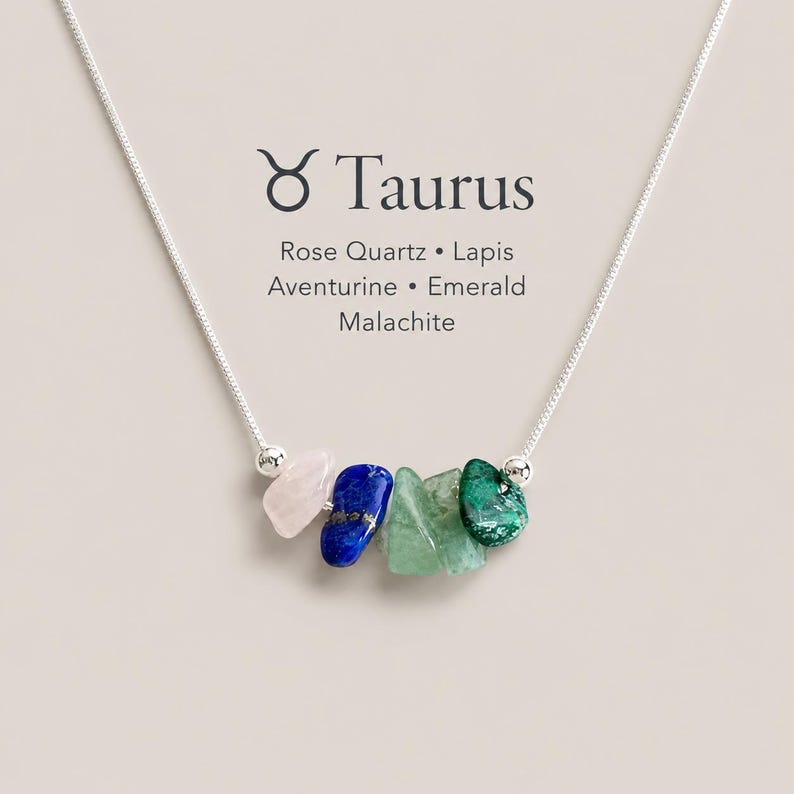 K&ouml;nnte beinhalten: Eine silberne Halskette mit f&uuml;nf rohen, getrommelten Edelsteinperlen in den Farben Hellrosa, Tiefblau, Hellgr&uuml;n und Dunkelgr&uuml;n. Der Text Taurus, Rose Quartz, Lapis, Aventurine, Emerald, Malachite ist &uuml;ber den Steinen aufgedruckt.