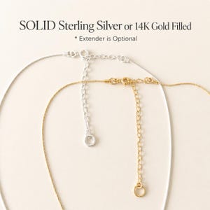 May include: Close-up of two necklaces, one silver and one gold, with extender chains. The silver necklace is on the left, and the gold necklace is on the right. Text at the top reads "SOLID Sterling Silver or 14K Gold Filled".