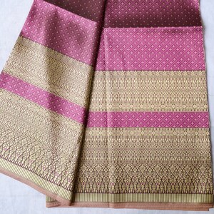 May include: A folded piece of fabric with a brown and pink patterned design. The fabric has a gradient of color from brown to pink. The fabric has a gold trim.