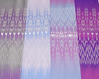 May include: Four fabric swatches with a gradient pattern. The swatches are in shades of grey, light blue, lavender, and purple. The pattern is a white ikat design.