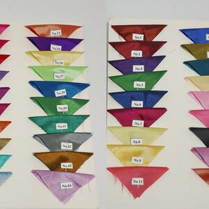 May include: A display of fabric swatches in various colors, arranged in rows. Each swatch is a small, triangular piece of fabric, with a label indicating a number. Colors range from pinks and reds to blues and greens.