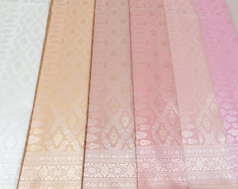 May include: A collection of six fabric swatches in various shades of pink and white with a subtle embossed pattern. The fabric has a silky sheen and a delicate floral design.
