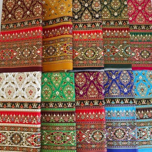 May include: A collection of colorful, patterned fabrics. The textiles feature intricate designs with a variety of colors, including red, gold, black, green, and blue. The patterns include floral and geometric elements, creating a rich visual texture.