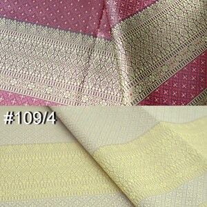 May include: Two pieces of fabric with intricate patterns. The top piece is a burgundy fabric with a gold and white pattern. The bottom piece is a beige fabric with a gold and white pattern. The fabric is labeled #2 and #109/4.