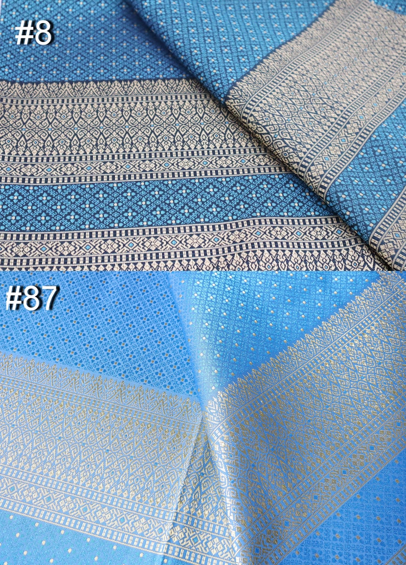 May include: Two pieces of blue fabric with gold and white patterns. The top piece is a darker blue with a more intricate pattern. The bottom piece is a lighter blue with a simpler pattern. The fabric is labeled #8 and #87.