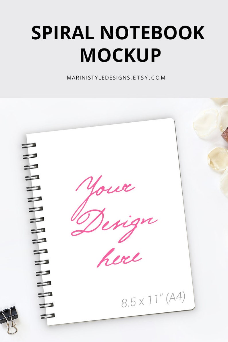 K&ouml;nnte beinhalten: Wei&szlig;es Spiralnotizbuch-Mockup mit dem Text "Spiral Notebook Mockup" und "Your Design here" in Pink. Das Notizbuch ist im A4-Format (21 x 29,7 cm) und hat eine schwarze Spiralbindung. Eine schwarze B&uuml;roklammer befindet sich in der unteren linken Ecke.