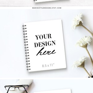 May include: Three white spiral notebooks with black text that reads "YOUR DESIGN here". The top notebook has the text "MARINISTYLEDESIGNS.ETSY.COM" below the design. The middle notebook has the text "8.5 x 11" below the design. The notebooks are on a white wood surface.