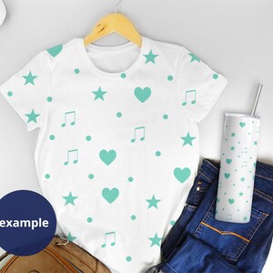 May include: White t-shirt with a teal blue pattern of stars, hearts, and music notes. The t-shirt is on a hanger and there is a teal blue patterned tumbler next to it.