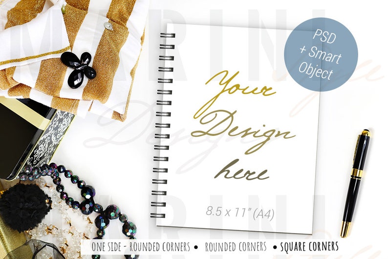 May include: A white spiral-bound notebook with the text "Your Design here" in gold script. The notebook is 21.6 x 27.9 cm (A4) and has rounded corners. A black and gold pen rests beside it, with other accessories.