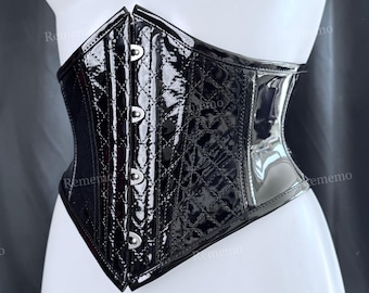 May include: A black corset featuring a glossy patent finish with a quilted diamond pattern on the front panels. The garment includes a vertical row of silver-toned metal busk closures and smooth, solid black side panels on a mannequin.