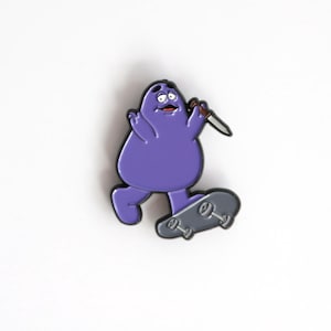 May include: Purple cartoon character holding a knife and riding a skateboard. The character has a surprised expression on its face.