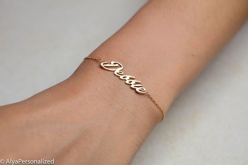 K&ouml;nnte beinhalten: Goldenes Namensarmband mit dem Namen "Debbie" in Kursivschrift.