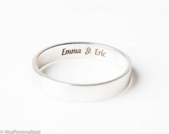 May include: A silver band ring with the inscription "Emma & Eric" engraved on the inside.