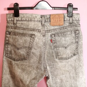 May include: A pair of grey acid wash denim jeans with a Levi's label on the back pocket.