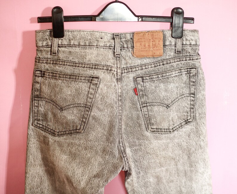 May include: A pair of grey acid wash denim jeans with a Levi's label on the back pocket.