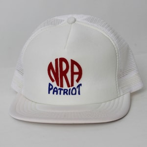 Puede incluir: Gorra de camionero de malla blanca con un logotipo bordado en rojo y azul que dice "NRA PATRIOT"