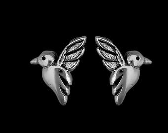 Könnte beinhalten: Ein Paar silberne Ohrringe in Form von Kolibris. Die Kolibris sind im Flug mit ausgebreiteten Flügeln.