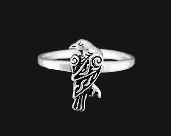 May include: A silver ring with a detailed raven design. The raven is facing to the right and has intricate details on its wings and body.