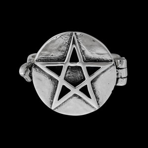 May include: A silver ring with a hinged lid that opens to reveal a small compartment. The lid features a raised, five-pointed star design.