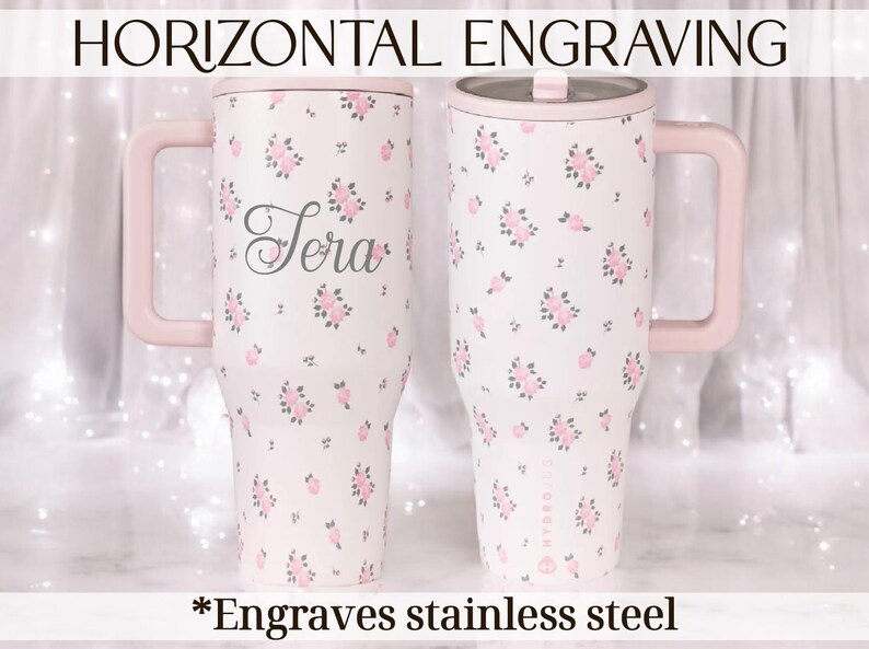 May include: Two stainless steel tumblers with pink handles and lids. The tumblers are white with a pink floral pattern and the name "Sera" is engraved on one. The text "Horizontal Engraving" and "*Engraves stainless steel" are also visible.