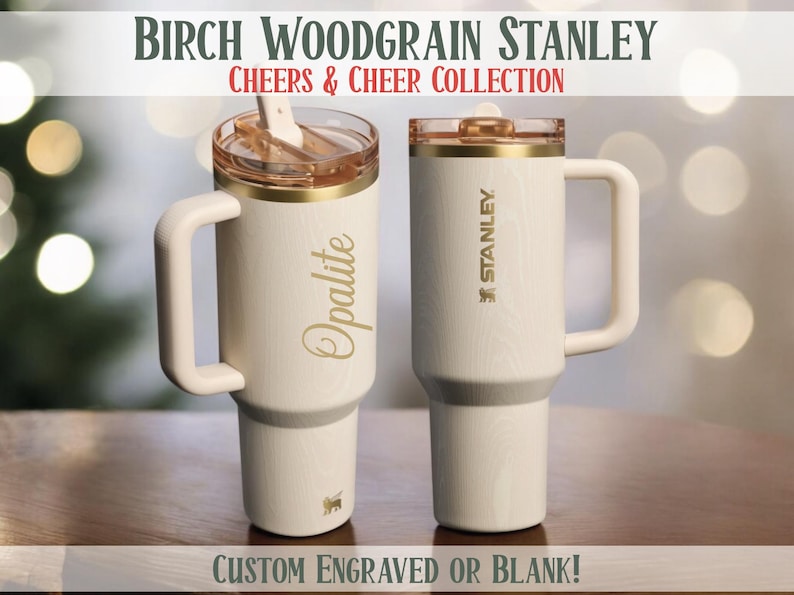 May include: Two cream-colored Stanley tumblers with gold accents and handles. One has "Opalite" in gold script, the other has the Stanley logo. The text "BIRCH WOODGRAIN STANLEY" and "CHEERS & CHEER COLLECTION" are at the top. The bottom reads "CUSTOM ENGRAVED OR BLANK!"