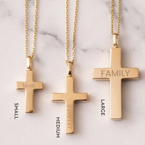 May include: Three gold cross necklaces with different sizes and engravings. The smallest cross is engraved with "Mom", the medium cross is engraved with "Forever", and the largest cross is engraved with "FAMILY".