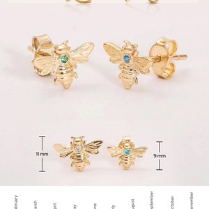May include: Gold-colored bee stud earrings with gemstone accents. The earrings are available in various birthstone colors and two sizes, 11 mm and 9 mm. The image shows screw back and push back closure styles.
