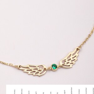 Puede incluir: Un collar dorado con alas caladas y una gema verde central. El delicado collar de cadena incluye una selecci&oacute;n de gemas de colores que representan los meses de nacimiento.