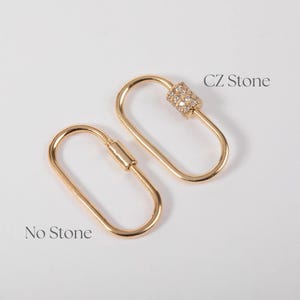 May include: Two gold-coloured oval carabiner clasps. One clasp is adorned with CZ stones, while the other is plain. The text "CZ Stone" and "No Stone" are printed near each clasp. The clasps are displayed on a white background.