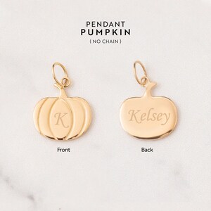 Puede incluir: Colgante de calabaza de color dorado con una inscripci&oacute;n en la parte delantera de la letra "K" y una inscripci&oacute;n en la parte posterior del nombre "Kelsey".