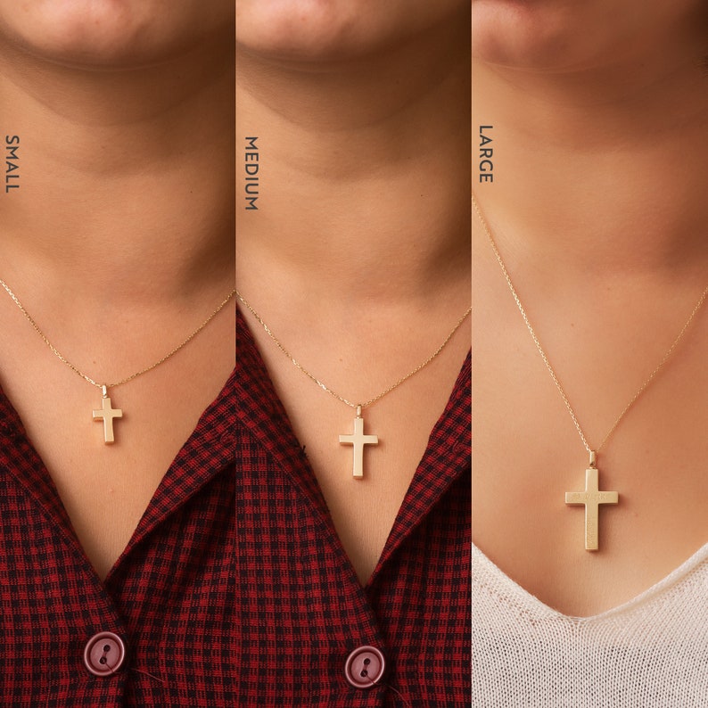May include: Three gold cross necklaces on models, showing the different sizes: small, medium, and large. The necklaces are on a plain background.