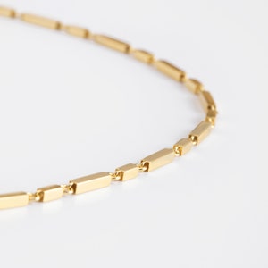 Puede incluir: Un collar de cadena de oro con un diseño de eslabones rectangulares.