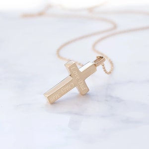 May include: Gold cross necklace with an inscription that reads "Love Dad Crazy Man".