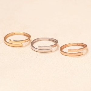 Minimalist plain gold bands in three gold colors for personalized engraved name ring designs.