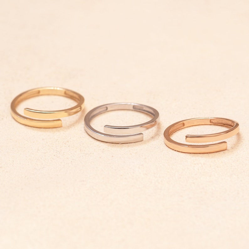 Minimalist plain gold bands in three gold colors for personalized engraved name ring designs.