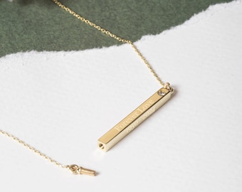 May include: A gold bar necklace with a small diamond accent. The bar is engraved with the words "Forever Love 1950-2024".