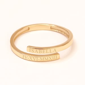 Classic script custom gold name ring with engraved text and date, minimalist wrap band design.