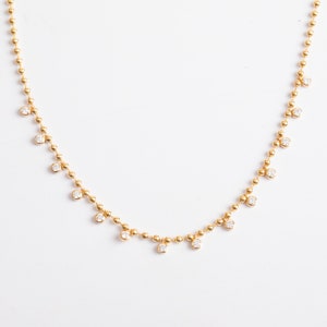 Pode incluir: Um colar de corrente de ouro com pequenos diamantes redondos pendurados na corrente.