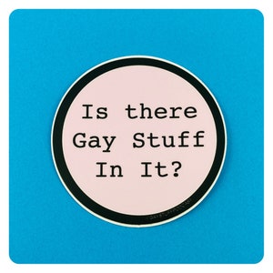 以下が含まれることがあります： 「Is there Gay Stuff In It?」と書かれたピンクと黒の丸いステッカー