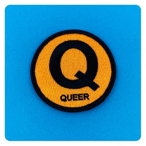 Puede incluir: Un parche bordado amarillo con una Q mayúscula negra y la palabra "QUEER" debajo.
