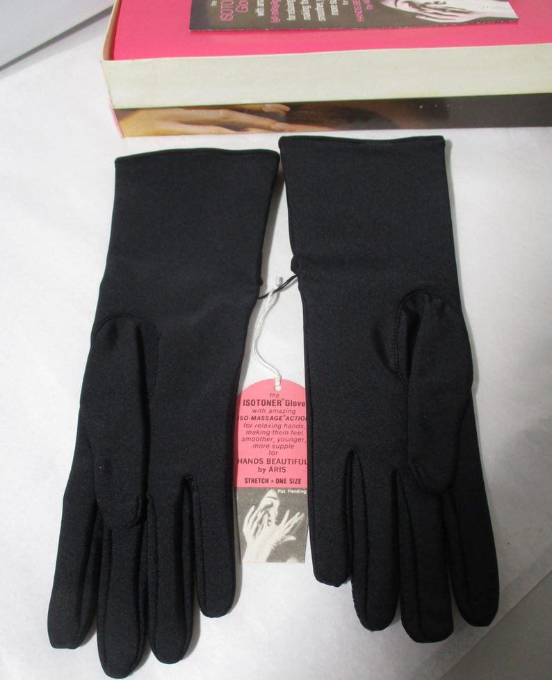 Pode incluir: Um par de luvas pretas Isotoner com uma etiqueta anexada. A etiqueta diz "SO-MASSAGE ACTION" e "HANDS BEAUTIFUL by ARIS". As luvas s&atilde;o el&aacute;sticas, tamanho &uacute;nico.