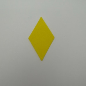 Könnte beinhalten: Ein flacher, einfarbig gelber, rautenförmiger Ausschnitt mit einer glatten, matten Oberfläche. Die geometrische Form weist vier gleich lange Seiten und spitze Ecken oben, unten und an den Seiten auf, präsentiert vor einem neutralen Hintergrund.