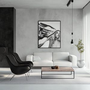 Pode incluir: Sala de estar moderna com um sof&aacute; branco, duas poltronas pretas e uma mesa de centro de madeira. Uma grande obra de arte abstrata em preto e branco est&aacute; pendurada na parede cinza. O quarto &eacute; minimalista com uma paleta de cores neutras e um toque de verde.