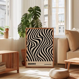 May include: A black and white abstract art print with wavy lines. The print is framed in a wooden frame and has the text "BAUHHAUS Ausstellung 1923" at the bottom.